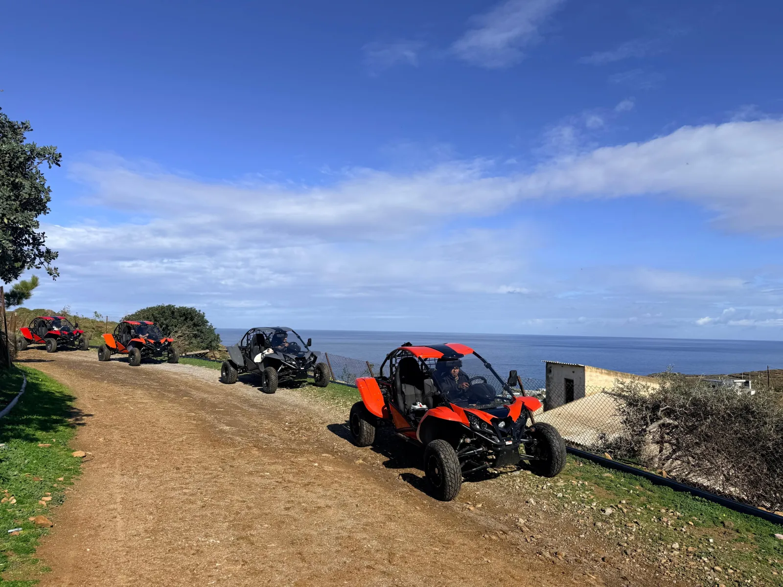 Buggies parked on a dirt track above the Mediterranean near Agia Pelagia