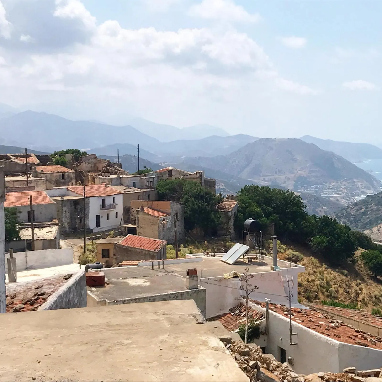 Rooftops of the abandoned village at Achlada against the mountains