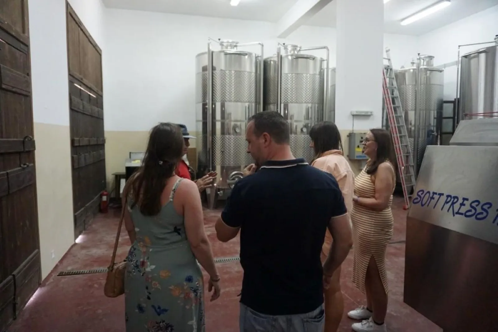 The group touring the winery beside its stainless fermentation tanks