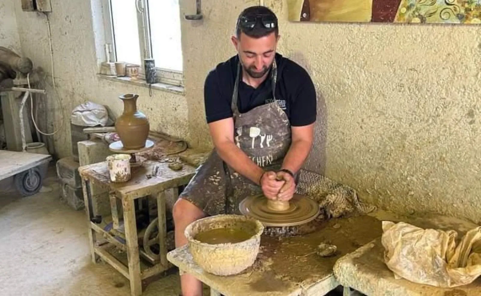 The potter shaping a large vessel by hand in his workshop