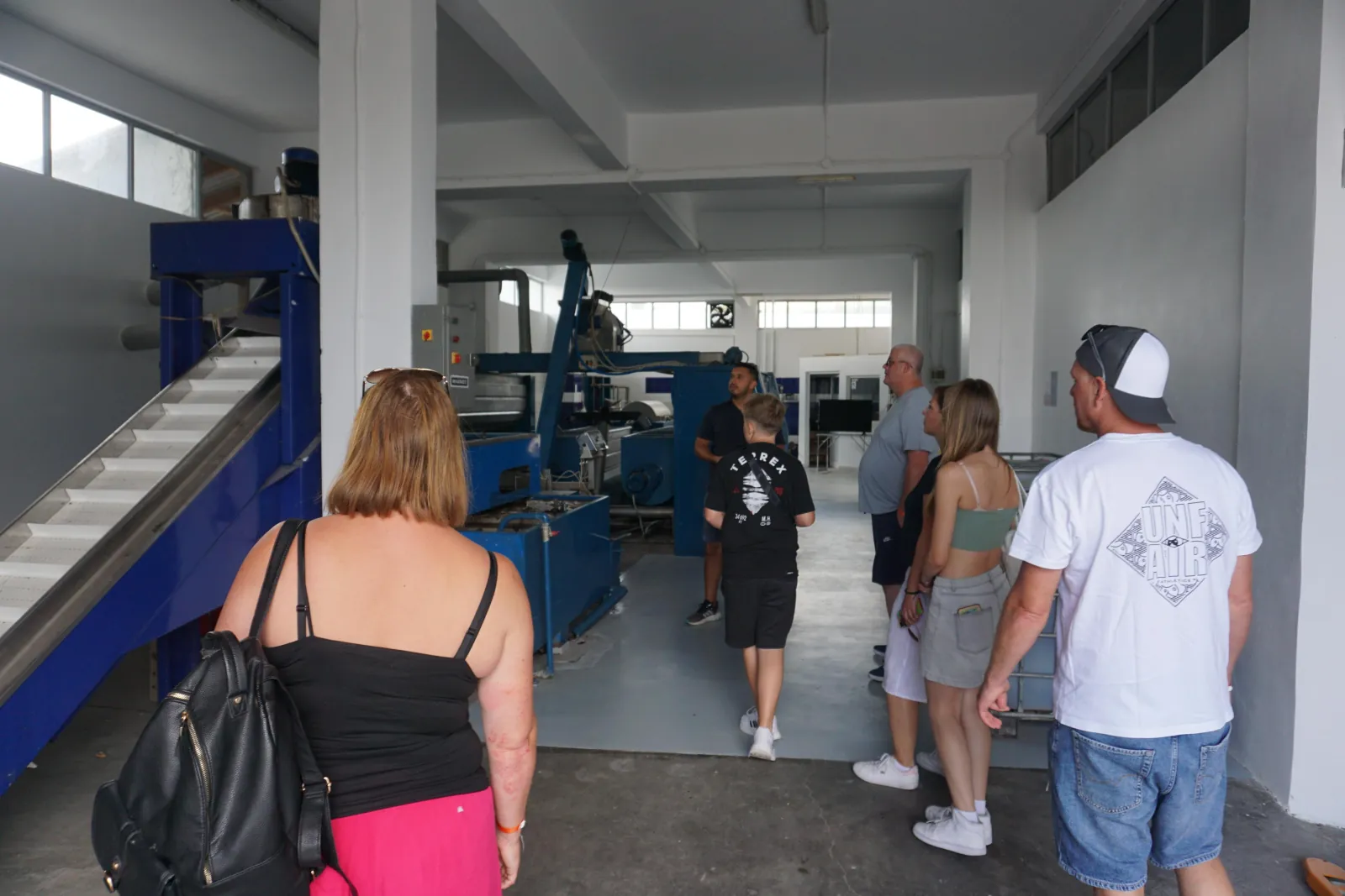 Guests walking the olive mill floor past the pressing equipment