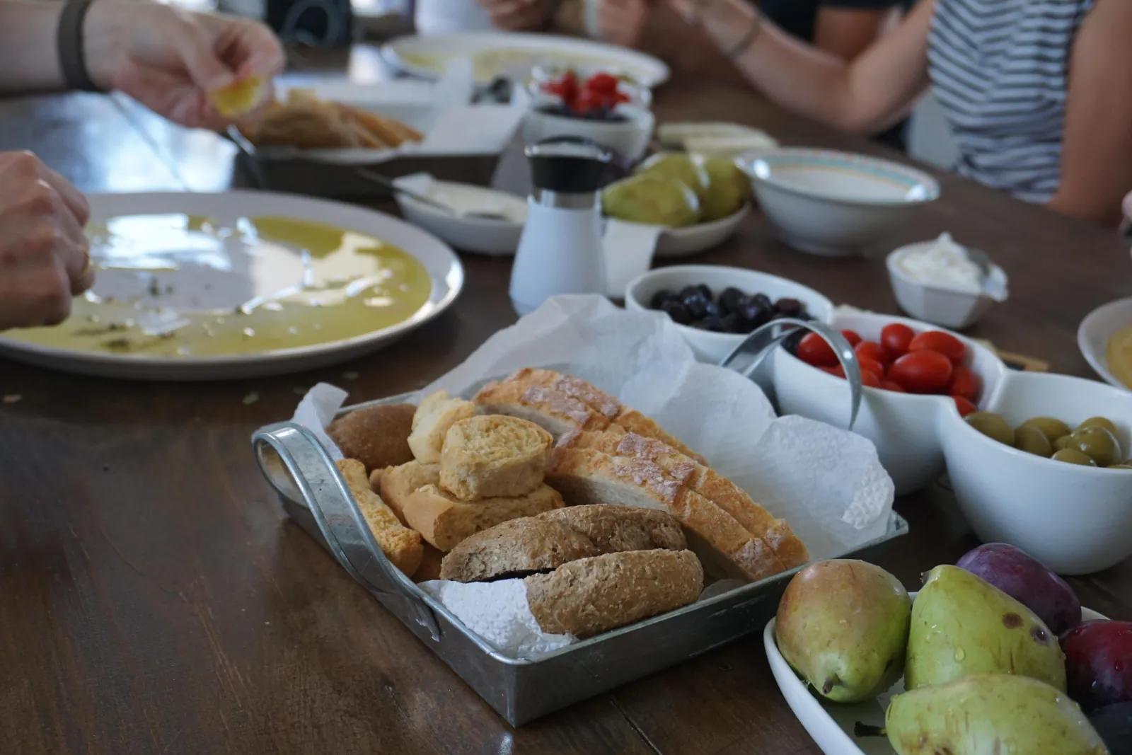 The lunch table spread with Cretan dishes, bread and fresh olive oil